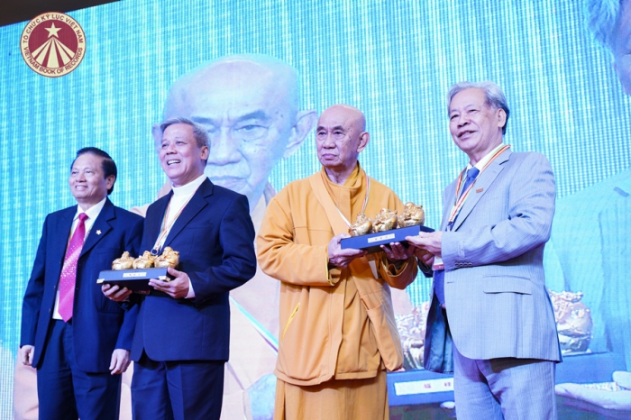 Linh mục Tạ Huy Hoàng đón nhận món quà lưu niệm từ Lãnh đạo Tổ chức Kỷ lục Việt Nam tại Hội ngộ