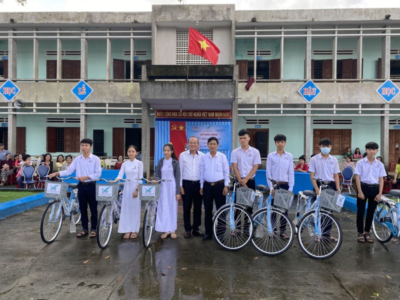 Ông Nguyễn Thành Long - Chủ tịch Hội đồng Quản lý Quỹ Tình Thương Việt (thứ 4 từ trái qua) trao xe đạp cho các em học sinh