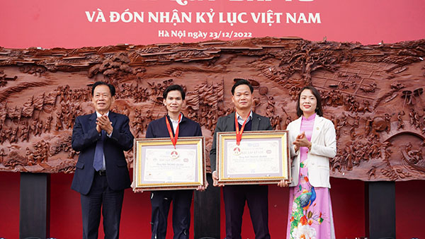 Tiến sĩ Thang Văn Phúc - Nguyên thứ trưởng Bộ nội vụ, Chủ tịch Trung ương Hội Kỷ lục gia Việt Nam (ngoài cùng bên trái) và Bà Phạm Thị Vân (ngoài cùng bên phải) trao bằng xác lập 2 kỷ lục Việt Nam đến ông Bùi Trọng Quân (thứ hai từ phải sang) tại sự kiện.