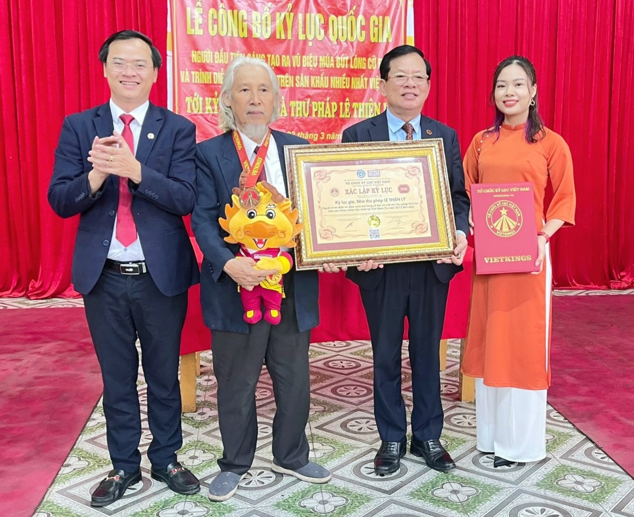 Ban lãnh đạo Tổ chức Kỷ lục Việt Nam trao bằng xác lập đến Kỷ lục gia-Nhà thư pháp Lê Thiên Lý.